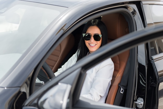 Hermosa joven dentro de un coche de lujo