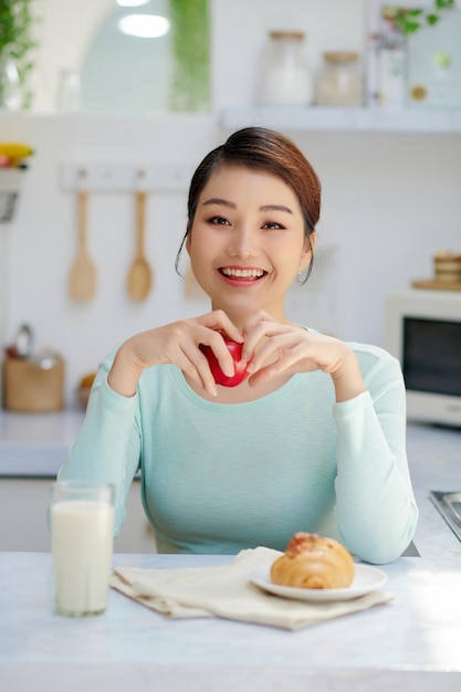 Hermosa joven desayunando en la cocina