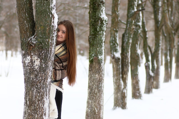 Hermosa joven en día de invierno cubierto de nieve al aire libre