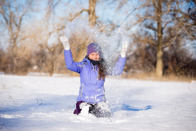 Hermosa joven disfruta de un paseo por el parque en invierno.