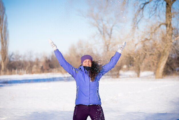 Hermosa joven disfruta de un paseo por el parque en invierno