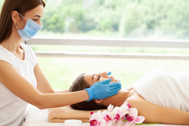 Hermosa joven disfrutando de un masaje en el salón de spa