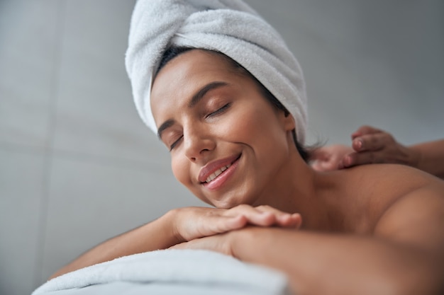 Hermosa joven disfrutando de un masaje en el salón de spa