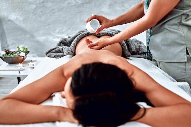 Hermosa joven disfrutando de un tratamiento de belleza de spa con un masaje a base de aceite Vista de cerca