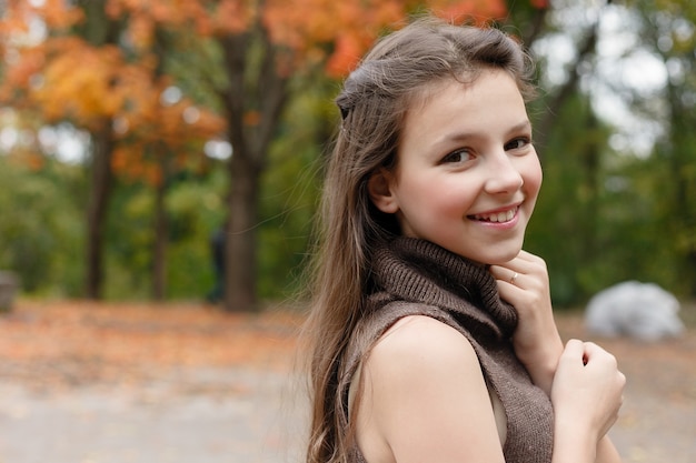 Hermosa joven divirtiéndose en el parque otoño