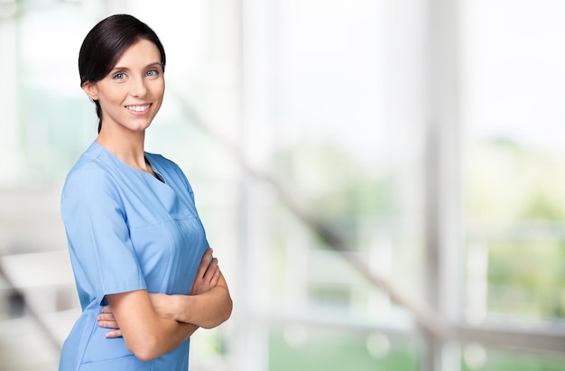 Hermosa joven doctora sonriendo con uniforme de trabajo