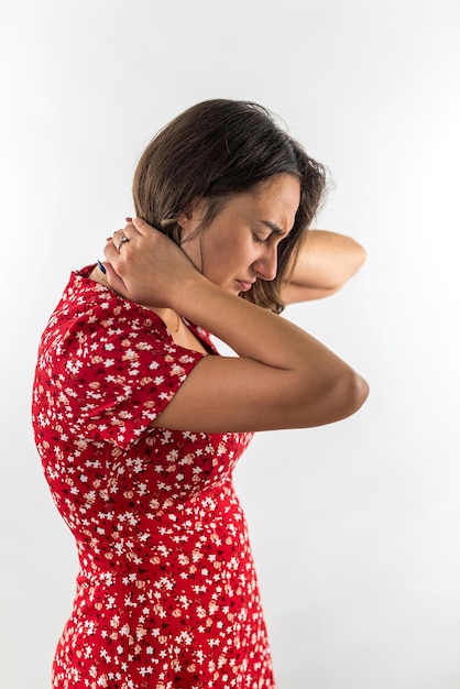 Hermosa joven con dolor de cuello sosteniendo el cuello con las manos aisladas sobre fondo blanco La niña sufre de osteocondrosis dolor de cuello con las manos en el cuello