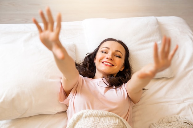 hermosa joven en el dormitorio yace sobre una almohada