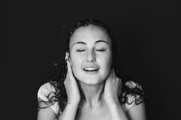 Hermosa joven bajo la ducha cae retrato en blanco y negro