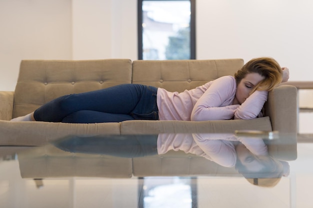 Hermosa joven durmiendo en el sofá en casa