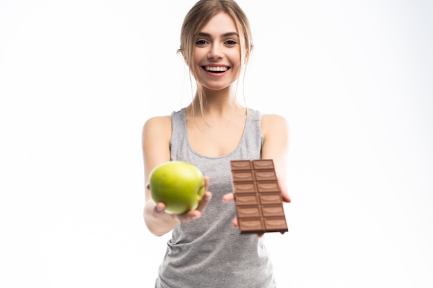 Hermosa joven eligiendo entre alimentos saludables y no saludables