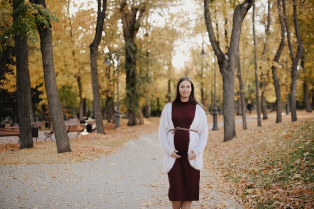 Hermosa joven embarazada en el parque de la ciudad