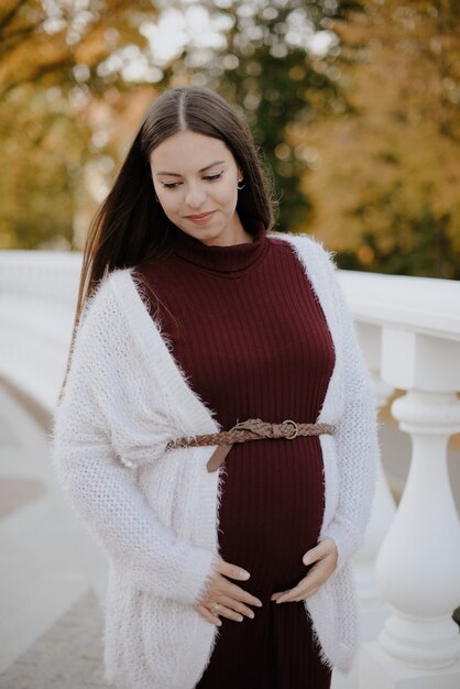 Hermosa joven embarazada en el parque de la ciudad