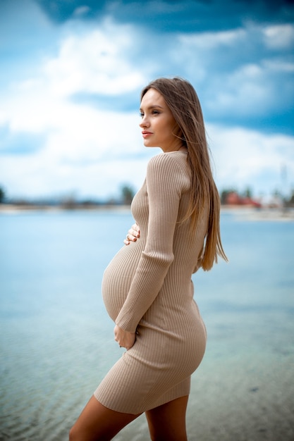 Hermosa joven embarazada en una playa