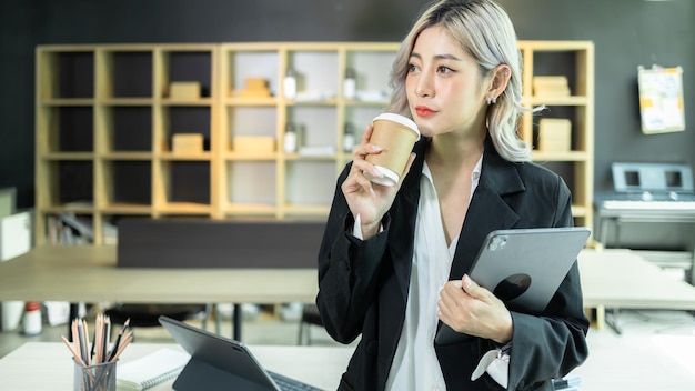 Hermosa joven empresaria asiática joven emprendedora independiente PYME Mujer asiática propietaria de una pequeña empresa con tableta digital