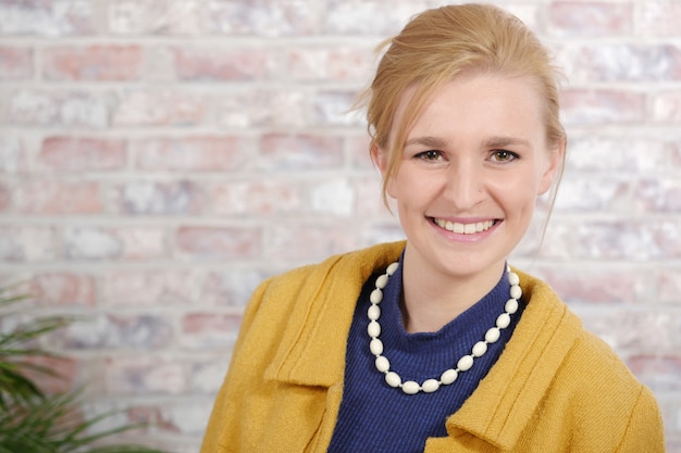 Hermosa joven empresaria con una chaqueta amarilla