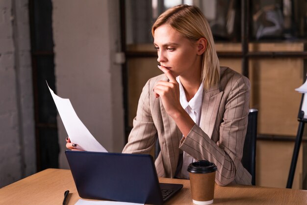 Hermosa joven empresaria con elegante vestido formal trabajando en una empresa