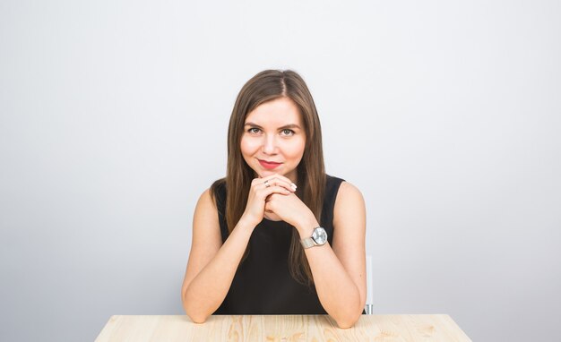 Hermosa joven empresaria sentado en la mesa sobre fondo blanco.