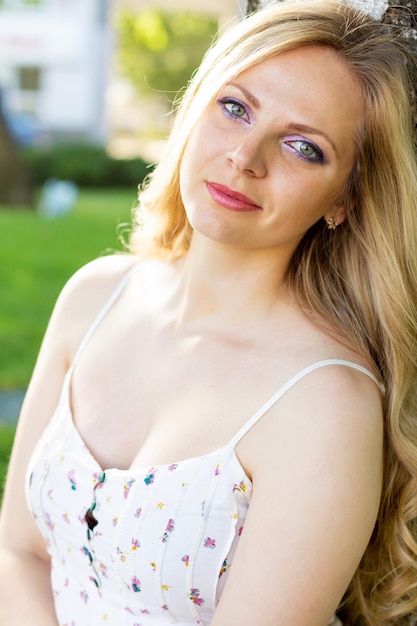 Hermosa joven se encuentra en un claro entre flores blancas Flores blancas Manzanilla Una niña con el pelo en un vestido blanco