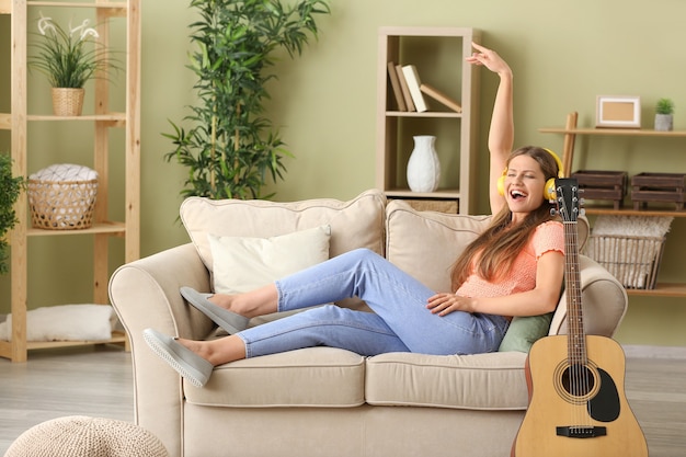 Hermosa joven escuchando música en casa