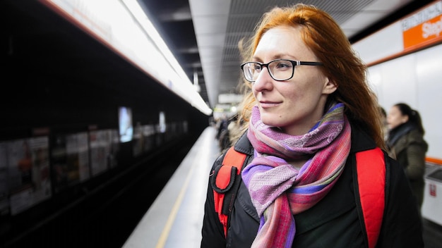 Hermosa joven esperando el metro en el metro, cerrar