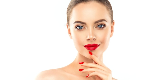 Una hermosa joven con un espléndido maquillaje está tocando la cara con los dedos graciosos Manicure de maquillaje