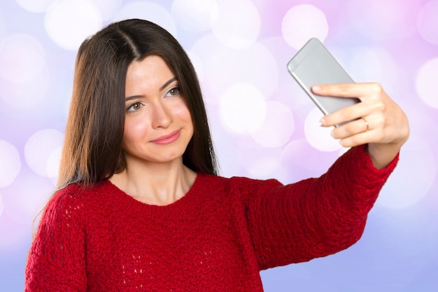 Hermosa joven está haciendo foto selfie con smartphone