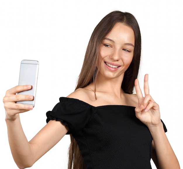 Hermosa joven está haciendo foto selfie con smartphone