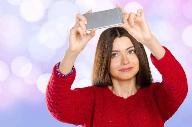 Hermosa joven está haciendo una foto selfie con un teléfono inteligente