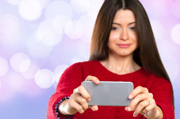 Hermosa joven está haciendo una foto selfie con un teléfono inteligente