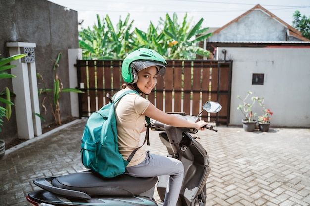 Hermosa joven está sentada en la motocicleta