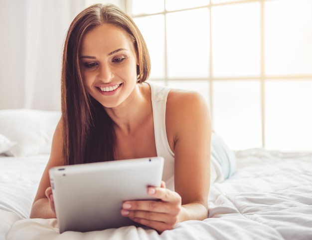 Hermosa joven está usando una tableta digital