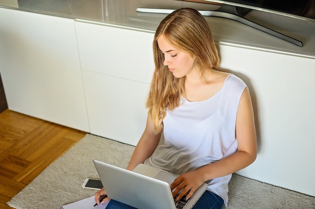 Hermosa joven estudiando en casa, EE.