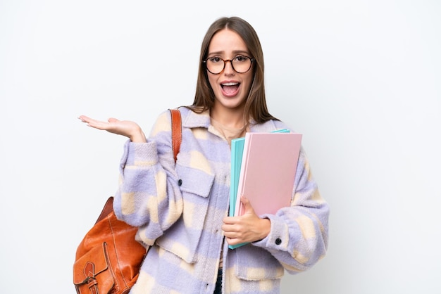 Hermosa joven estudiante mujer aislada sobre fondo blanco con expresión facial sorprendida