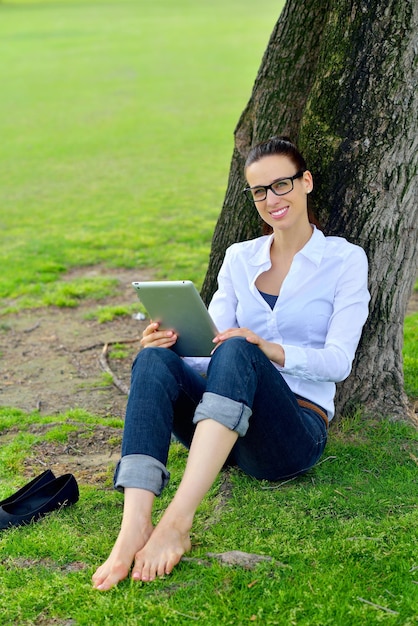 Hermosa joven estudiante mujer estudio con tableta en el parque