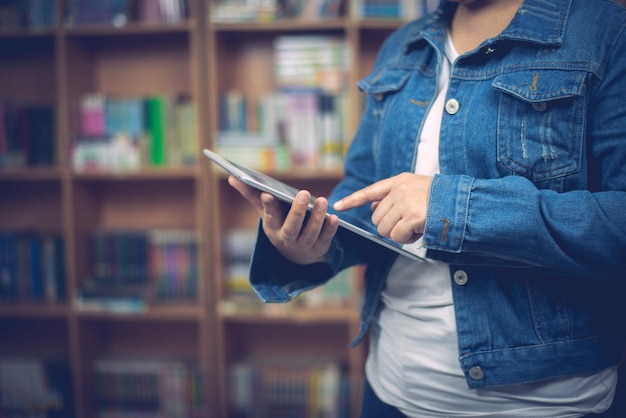 Hermosa joven estudiante trabajando aprendiendo en la biblioteca de la universidadUsando labtop