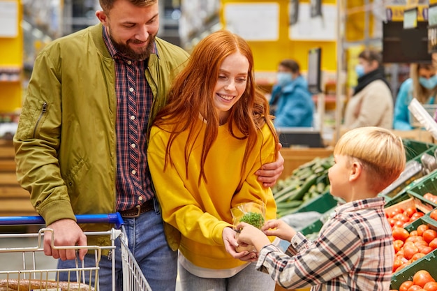 Hermosa y joven familia haciendo compras juntos