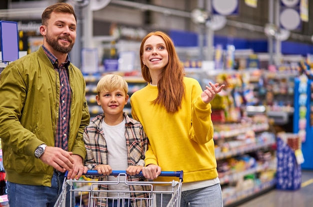 Foto hermosa y joven familia haciendo compras juntos