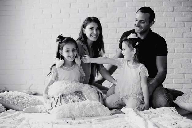 Hermosa joven familia con hijas en una sesión de fotos en un estudio blanco