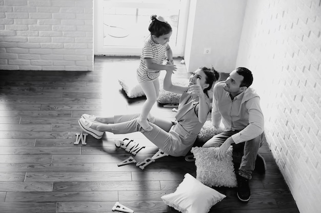 Hermosa joven familia con hijas en una sesión de fotos en un estudio blanco