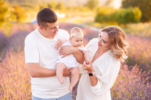 Hermosa joven familia, padre y madre con bebé en campo de lavanda