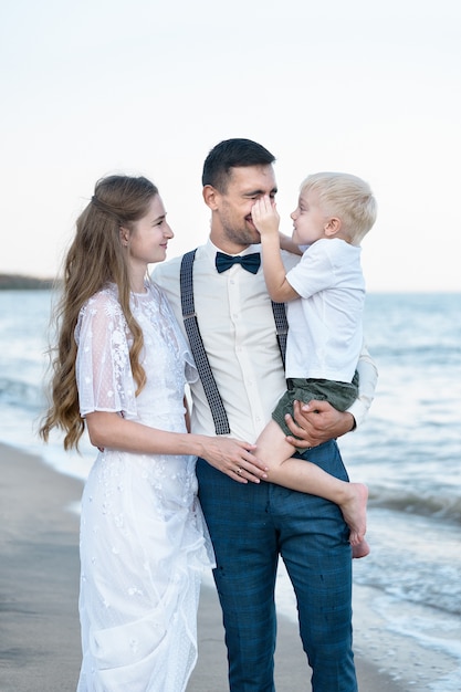 Hermosa joven familia, el Papa sostiene al hijo en sus brazos. Concepto de infancia y paternidad feliz.