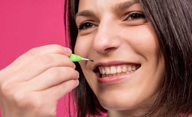 Hermosa joven feliz con cepillo interdental