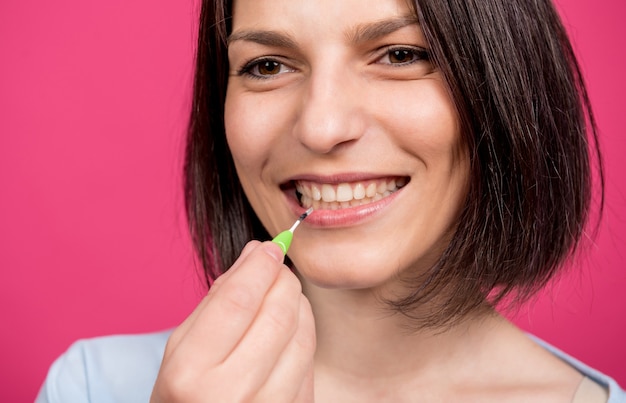 Hermosa joven feliz con cepillo interdental