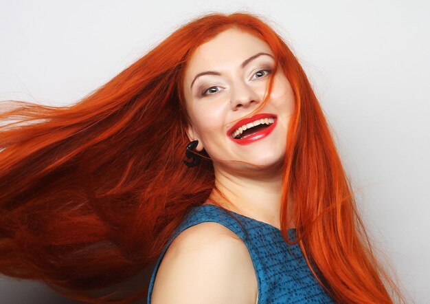 Hermosa joven feliz con largo cabello rojo que fluye