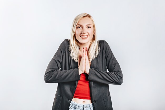 Hermosa joven feliz sonríe en gris aislado