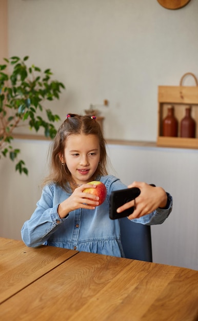 Hermosa joven filmando la transmisión de su blog sobre comida saludable en el hogar