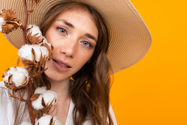 Hermosa joven con flores aisladas en amarillo