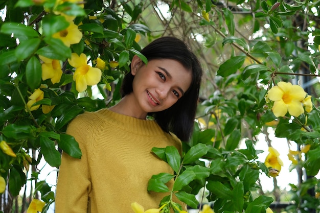 Hermosa joven de flores amarillas y suéter amarillo