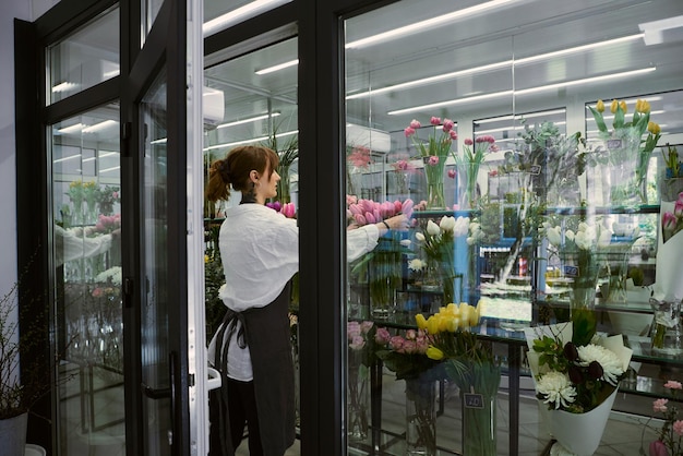 Hermosa joven florista hace un ramo